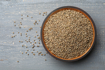 Organic hemp seeds on grey wooden table, top view. Space for text