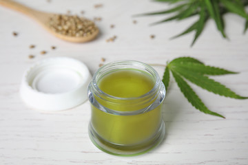 Jar of hemp cream on white wooden table. Organic cosmetics