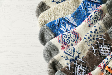 Soft knitted socks on white wooden background, flat lay. Winter clothes