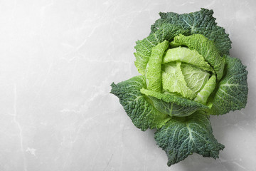 Fresh green savoy cabbage on marble table, top view. Space for text