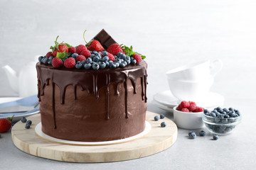 Freshly made delicious chocolate cake decorated with berries on white table
