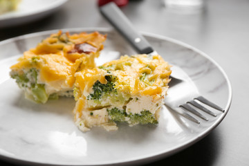 Pieces of tasty broccoli casserole on grey table