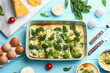 Flat lay composition with tasty broccoli casserole on blue wooden table