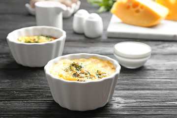 Tasty broccoli casserole in ramekins on black wooden table