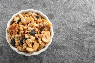 Bowl of tasty homemade granola on grey table, top view with space for text. Healthy breakfast