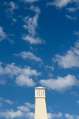 Cloudy blue sky in Algarve with a chimney.