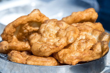 Freshly deep fried donuts, in display for sale at a street food market, photographed with soft focus