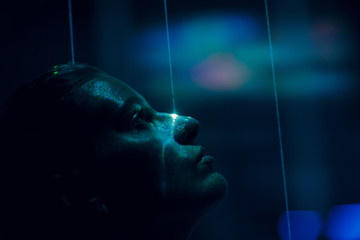 Young beautiful woman close up portrait with green laser beams