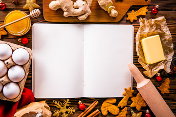 Traditional christmas holidays pastry ingredients, kitchen utensils and open blank notebook on wood textured table. Ginger cookies recipe concept. Close up, copy space, top view, flat lay, background.