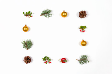 Creative flat lay of winter toys, berries, balls and cones on white background. Flat lay, top view. Holidays collection.