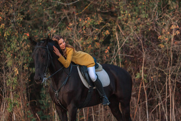 Lovely young girl hugs her horse.