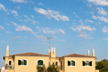 Fototapeta na wymiar Cloudy blue sky in Algarve with houses.