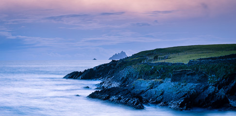 a viewpoint from bray head on valentia island in the ring of kerry in the south west coast of ireland during an autumn sunset showing the skellig islands and watchtower - obrazy, fototapety, plakaty
