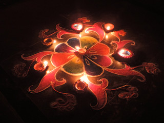Top view of round red blue green Diwali Rangoli pattern with dominant red orange