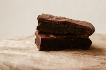 Slice of cake brauni on the wooden background. Bige and brown concept.