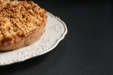 Vegetarian pie. Pie, apple, white plate. Gluten Free Apple Crisp pie on a dark table. Autumn concept.