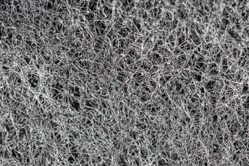Dark abstract background and pattern of interwoven hairs, fibers and nanofibers. Sponge detail texture, sponge texture closeup background. Cellulose sponge texture. Black and white