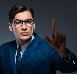 Businessman pressing virtual buttons on gray background