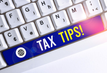 Writing note showing Tax Tips. Business concept for compulsory contribution to state revenue levied by government White pc keyboard with note paper above the white background