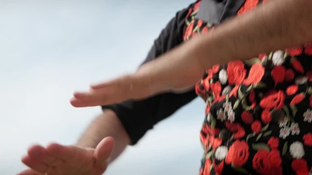 Man and woman dancing flamenco in park. Spanish people and traditional dance in Andalusia, Spain. Dancers performing traditional show in park. Couple and music arts. Detail of male hands