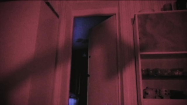 Vintage effect. The killer holds an ax in his hands. Shadow of the criminal on the wall. Halloween. The room is flooded with red light. 