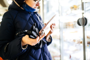 Close-up image of curious woman reading composition of a product from the fridge in Bio Organic supermarket