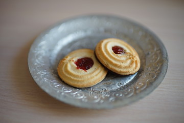 Two cookies in a vintage silver plate.