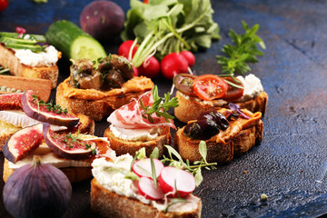 Assorted bruschetta with various toppings. Appetizing bruschetta or brie crostini. Variety of small sandwiches. Mix bruschetta on table