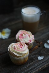Delicious cupcakes with cream and coffee on the table