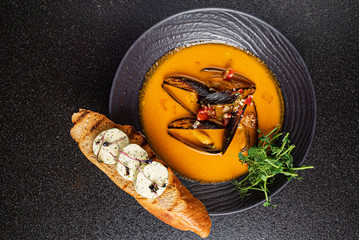 seafood soup with toast on the black background