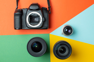 SLR camera with a set of different lenses on a colored background, the choice of device for the camera concept - Powered by Adobe