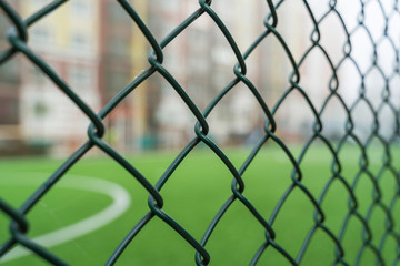 Fence netting close-up on a background of a soccer field