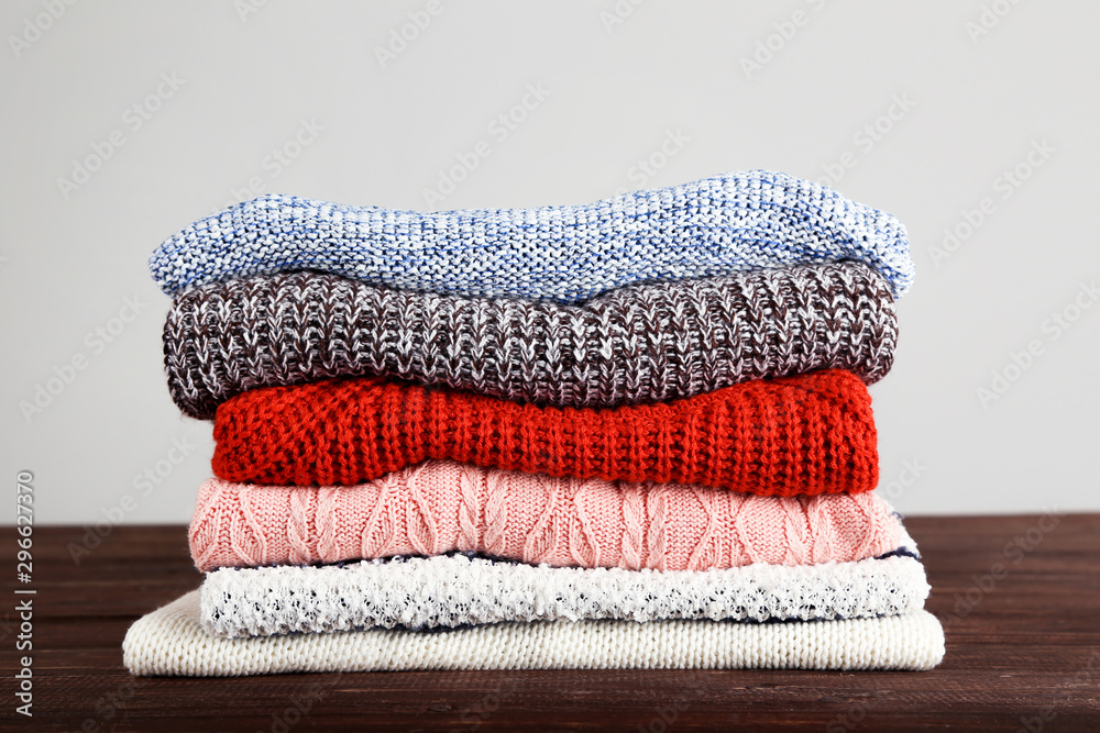 Sticker Folded knitted sweaters on grey background