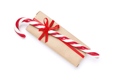 Tasty red candy cane and gift isolated on white background. Festive treat