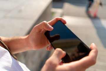 the guy holds the phone horizontally with 2 hands. with thumbs on the screen like a gamepad.