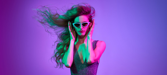 High Fashion. Party disco girl with pink neon hairstyle dance. Sensual woman in Colorful uv Light....