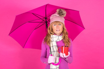 adult woman with winter clothes with cup and umbrella isolated on color background