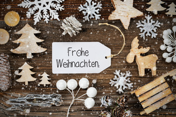 One White Label With German Text Frohe Weihnachten Means Merry Christmas. Frame Of Christmas Decoration Like Tree, Sled, Star And Fir Cone. Wooden Background With Snowflakes