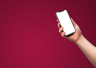 Woman hand holding smart phone with blank screen isolated on burgundy background. Template, mockup, model, modern, design.