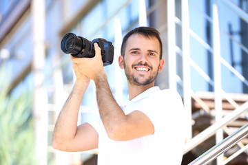 Young photographer with camera in the city