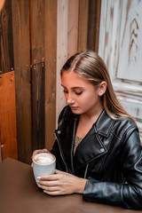 Beautiful woman drinking coffee at restaurant with soft light