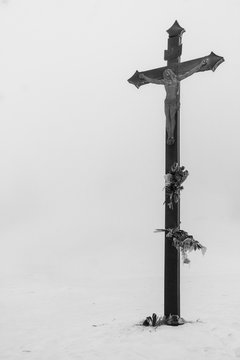 Wooden Jesus Christ cross in the middle of snowy winter landscape