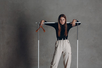 Young woman model with empty clothes hanger in the studio. Fashion and sale concept.