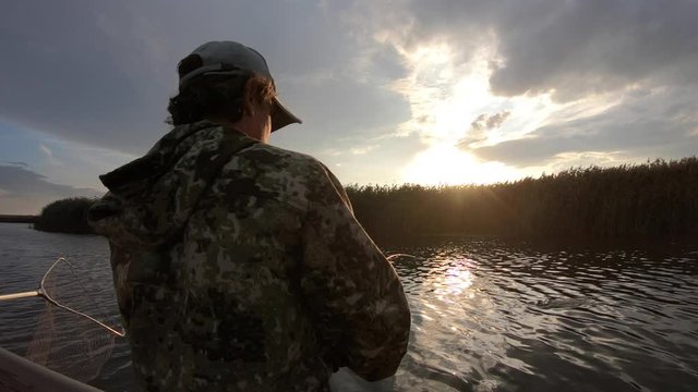 Amateur angler fights with the pike (Esox lucius) making aerial tricks