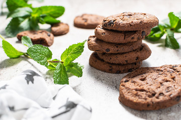 Fresh chocolate cookies with mint leaves on the table close up