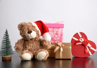 brown teddy bear and a stack of various cardboard boxes for gifts
