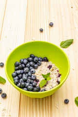 Oatmeal porridge with fresh blueberry, mint leaves and yogurt