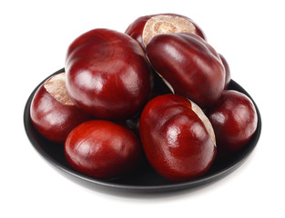 chestnuts in a black plate isolated on white background