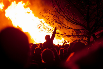Crowds of people gather in front of huge flames from bonfire for bonfire night in Rye, East Sussex, uk