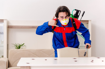 Young contractor doing pest control at home